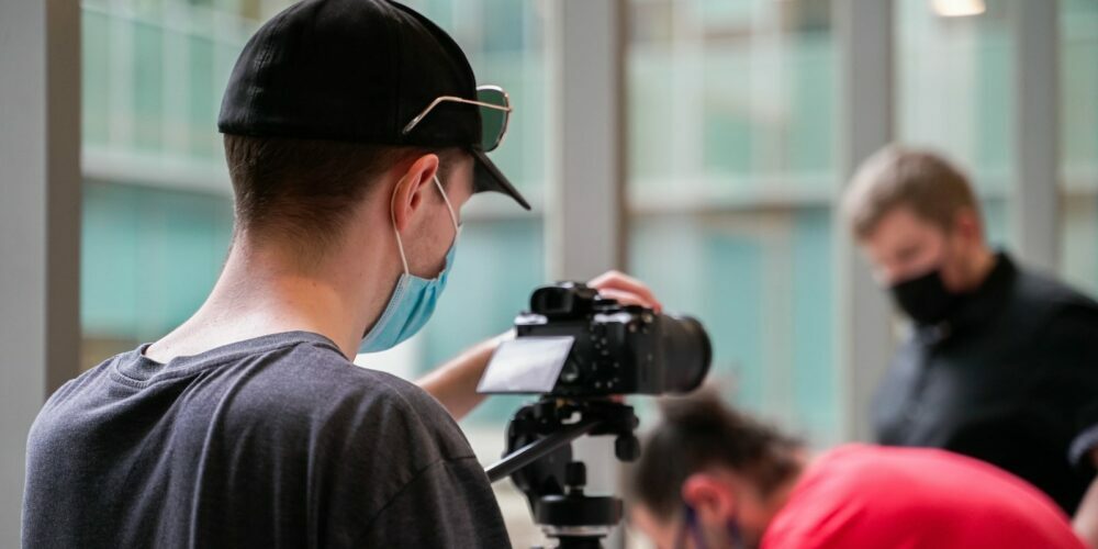 a man wearing a face mask while filming another man