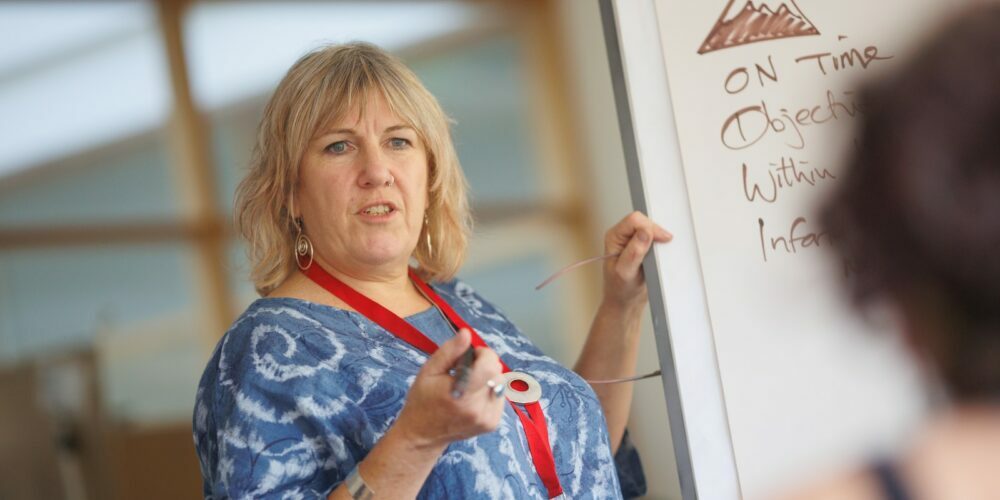 a person writing on a whiteboard