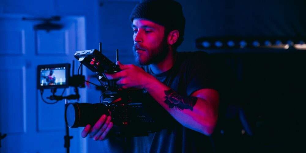 man in black t-shirt holding video camera