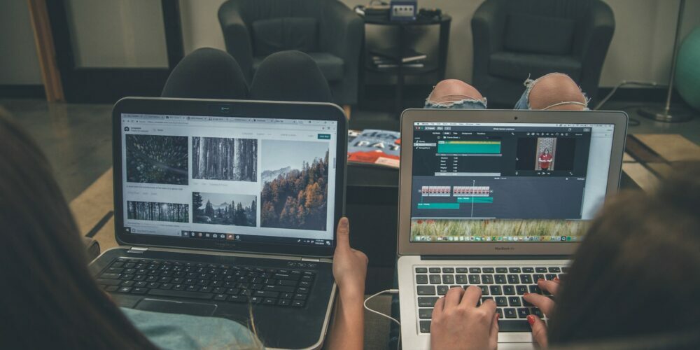 two person with laptop on lap sittig